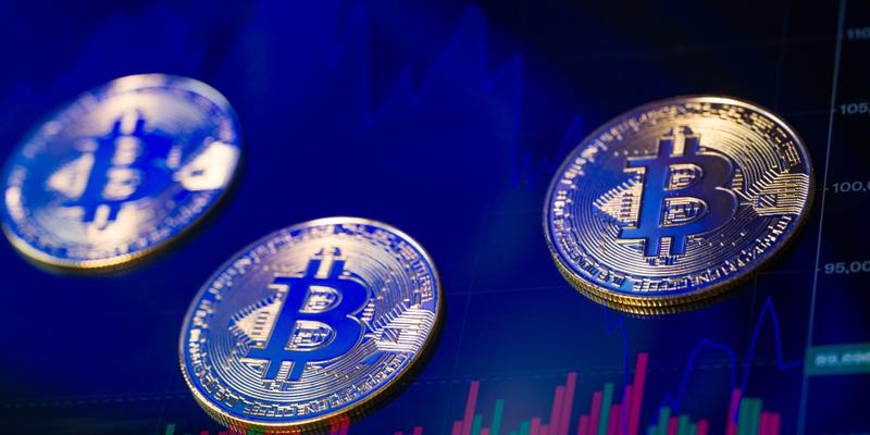 Bitcoin tokens against a blue trading screen