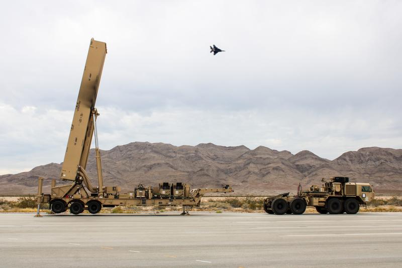 An Air Force F-16 flies over a Dark Eagle Long Range Hypersonic Weapon vehicle launcher during a training exercise at Nevada's Nellis Air Force Base., Aug. 2, 2024.