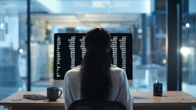 Woman sitting at a desk looking at a computer