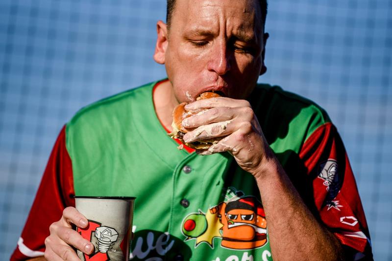 Nathan's Hot Dog Eating champion Joey Chestnut eats an olive burgers before the Lugnuts game against the TinCaps at Jackson Field in Lansing. Chestnut set a record with 13 olive burgers eaten in 5 minutes.