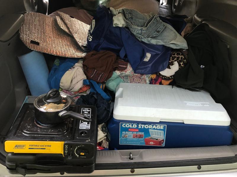 trunk with cooler, clothes, camper stove, and other items