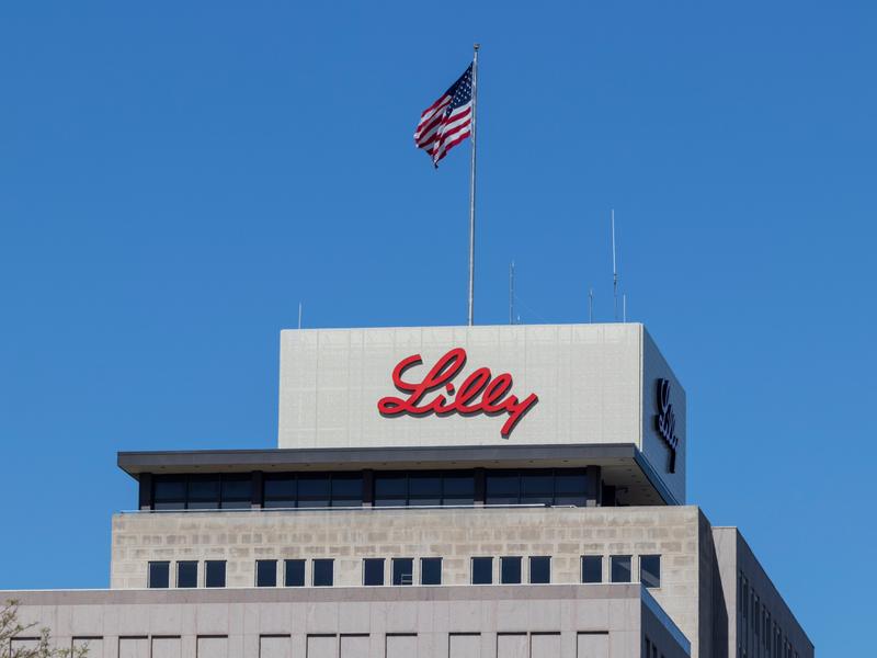 Eli Lilly logo on building under an American flag