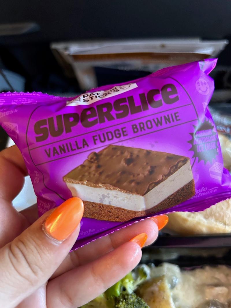 A hand holding a Superslice vanilla fudge brownie.