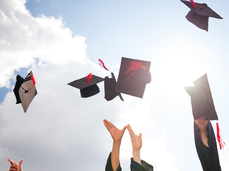 People throwing graduation caps