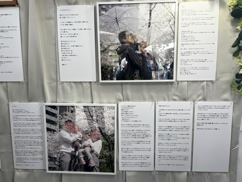 アーティスト、澄毅(すみ・たけし)さんによるアート作品。性的マイノリティの家族写真に施されたカラフルな刺繍は、社会の偏見ゆえに「素顔を隠さざるを得ない当事者の現状」を表現している。写真の横には、子どもへの手紙が添えられている。