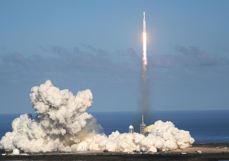 A Falcon Heavy rocket from SpaceX takes off from a launch pad in Florida during a clear day.