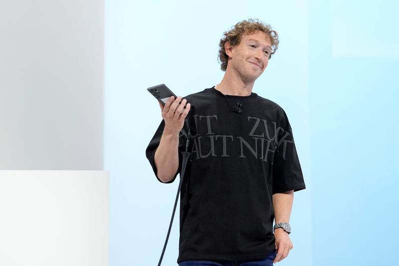 Mark Zuckerberg holds a phone and wears a F.P.Journe watch.