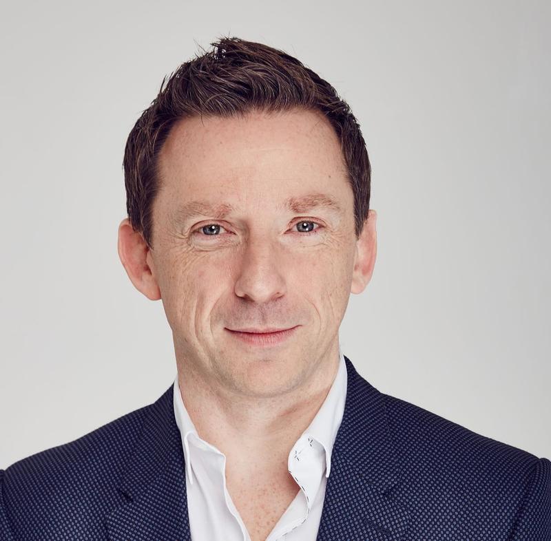 Headshot of man in blue jacket and white shirt