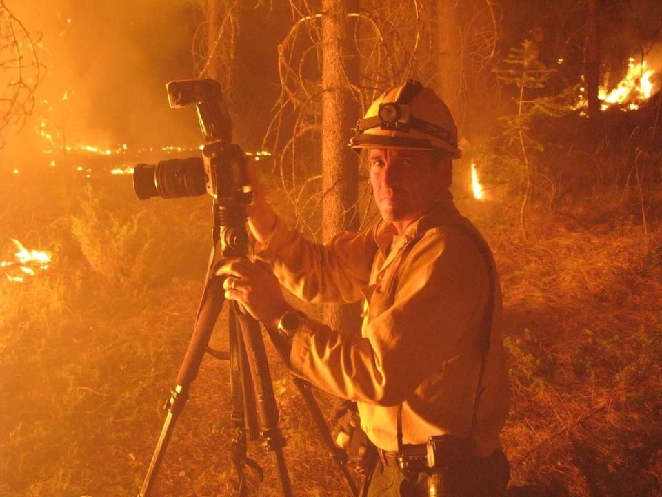 火事現場でカメラをかまえる男性