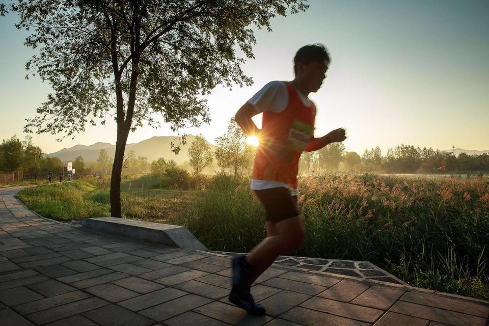 朝日を浴びながらランニングする男性