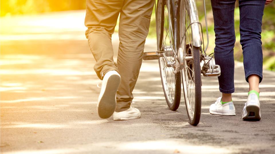 カップルが自転車を押す後ろ姿