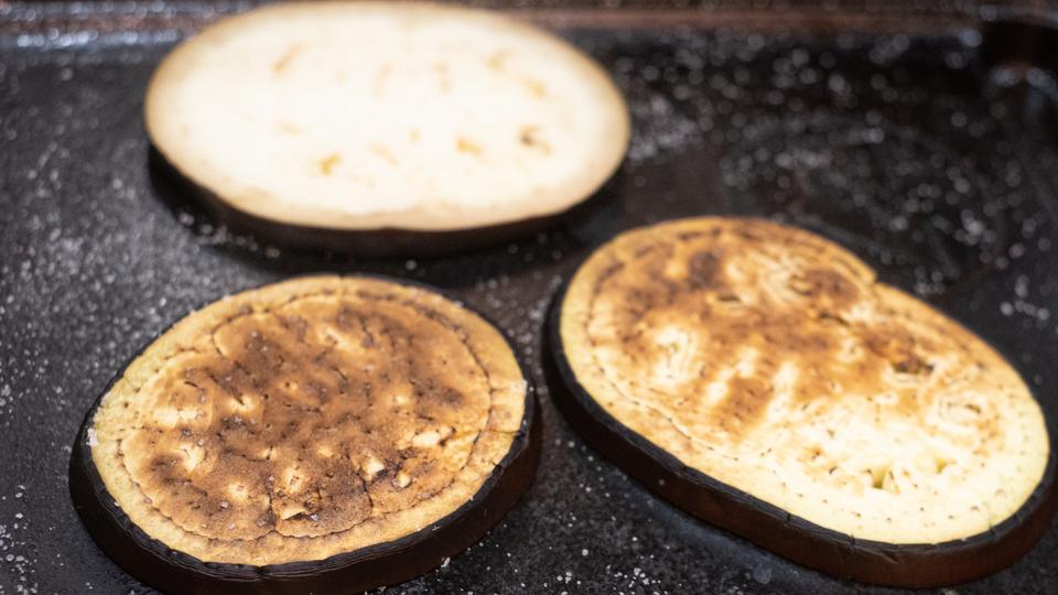 鉄板の上で焼かれる輪切りのナス