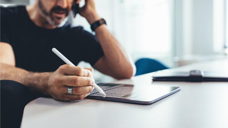 通話しながらタブレット操作する男性