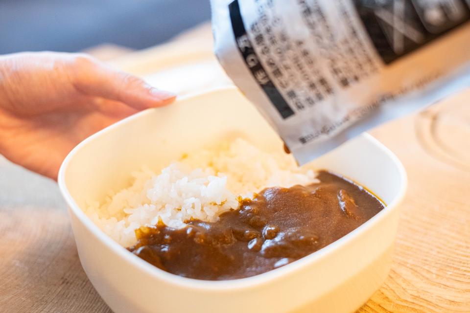 レトルト食品をお皿にそそぐ様子