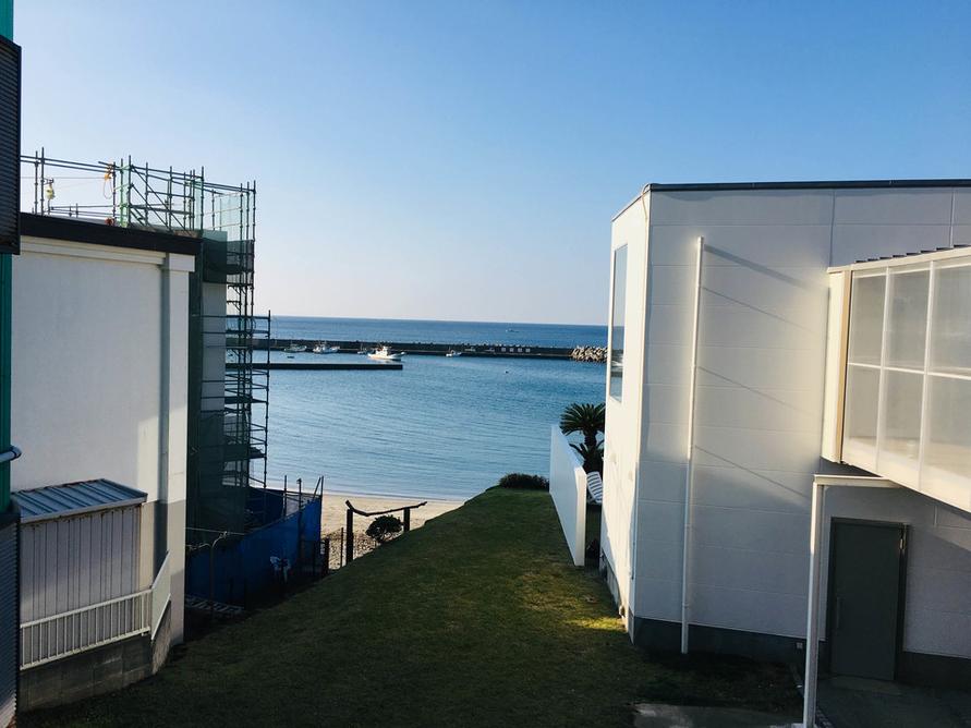 白い建物の脇から海がのぞいていた