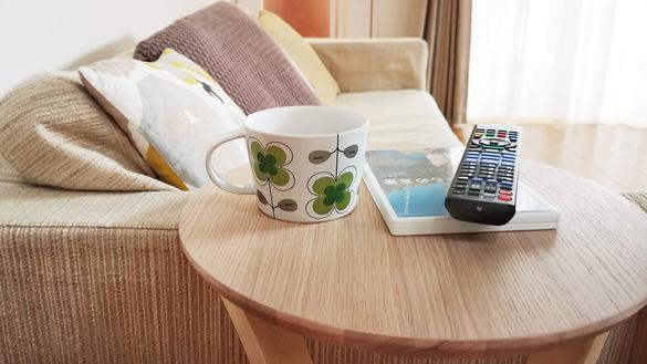 脚が曲がった木のサイドテーブルが、”ソファの上不便問題”を解決して