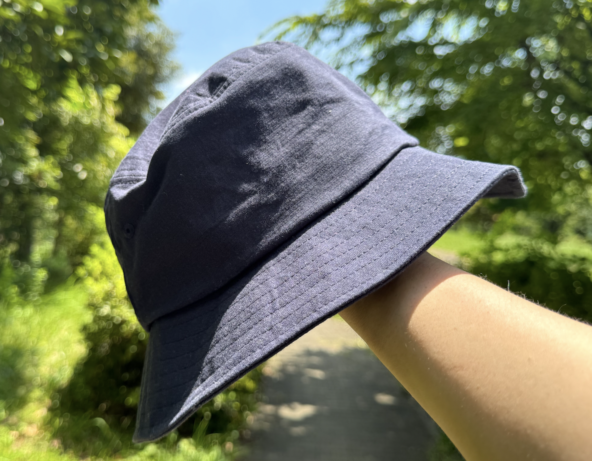 在烈日下手持コカゲル漁夫帽的樣子