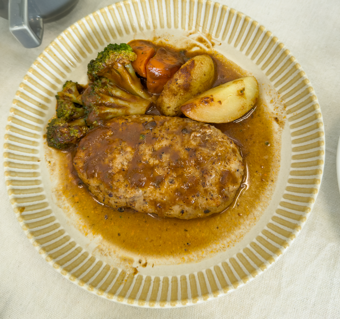 皿に盛り付けられた「野菜たっぷりデミグラスハンバーグ」