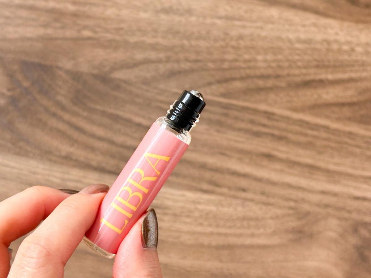 ミュシャ「ゾディアックサイン フレグランスオイル」を片手で持つ様子