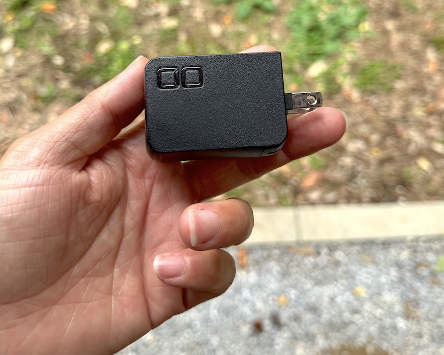 収納できるプラグを出したCIO nova port trioⅡ 67Wを手に持つ