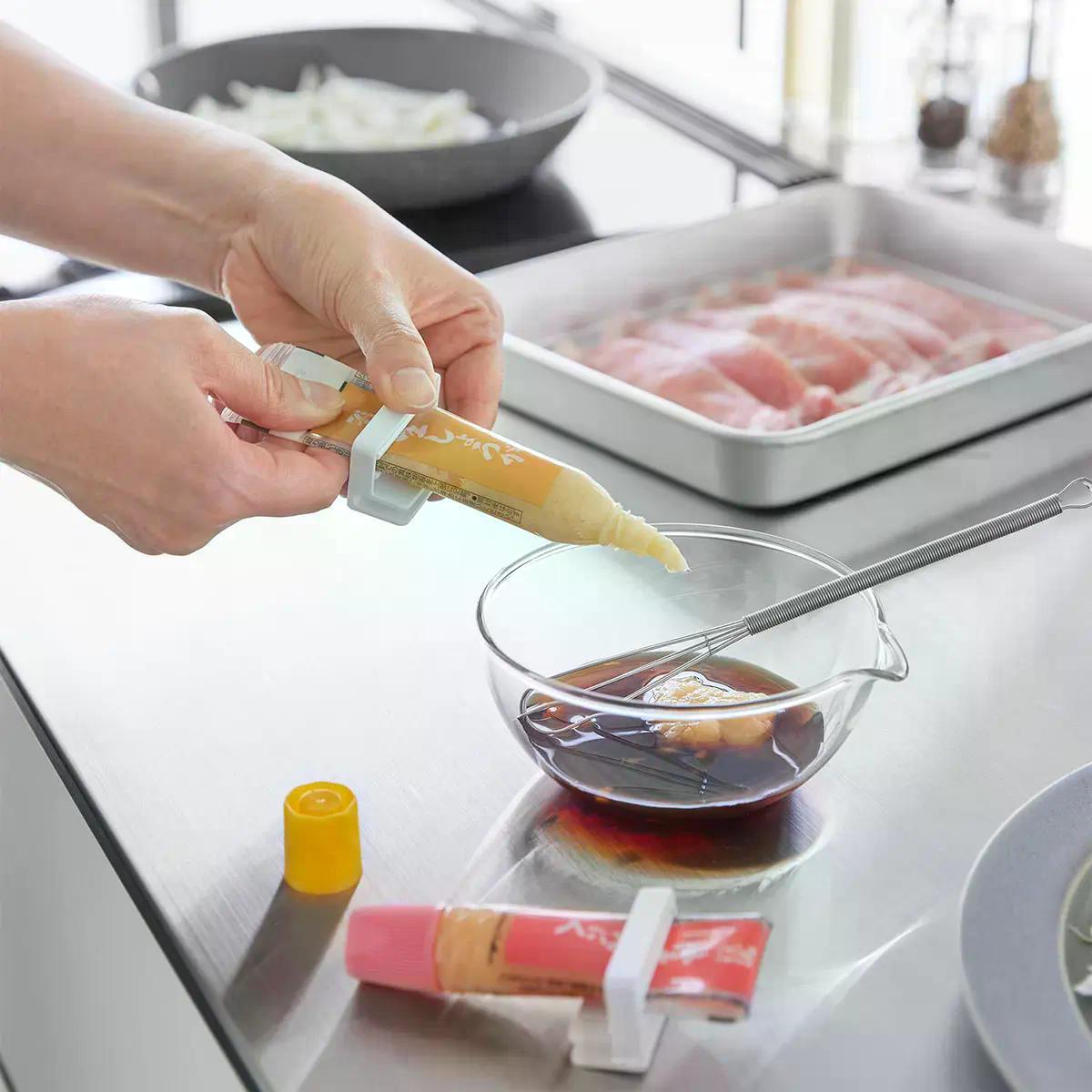 山崎実業「引っ掛け絞れる薬味チューブホルダー タワー 3個組」を絞っている様子