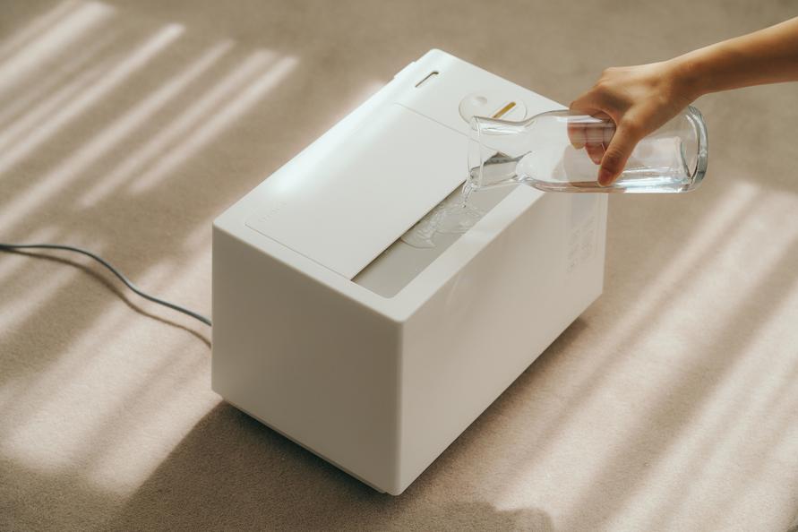 シロカの「加熱超音波式加湿器」の上部開口部から給水しているところ