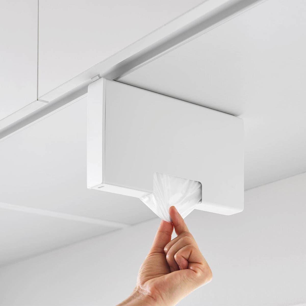 山崎実業の 「戸棚下ポリ袋収納ホルダー タワー スリム S」からポリ袋を取り出しているところ