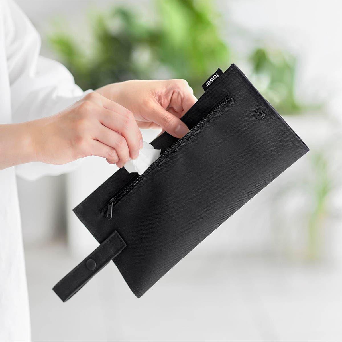 山崎実業「くず入れ付き折りたためる携帯ティッシュケース タワー」へゴミを入れているところ