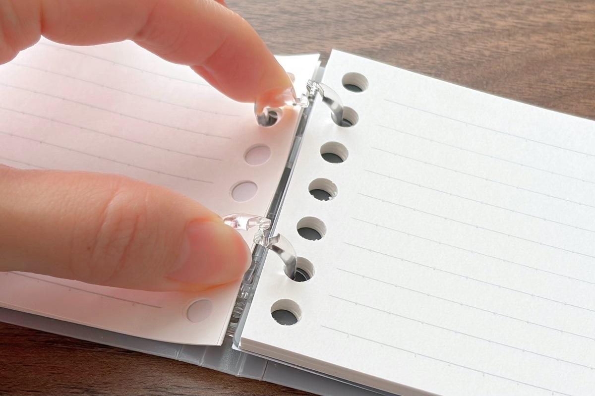 キャンパス「ノートのように使えるバインダー A7」のとじ具をつまんで外そうとしている様子