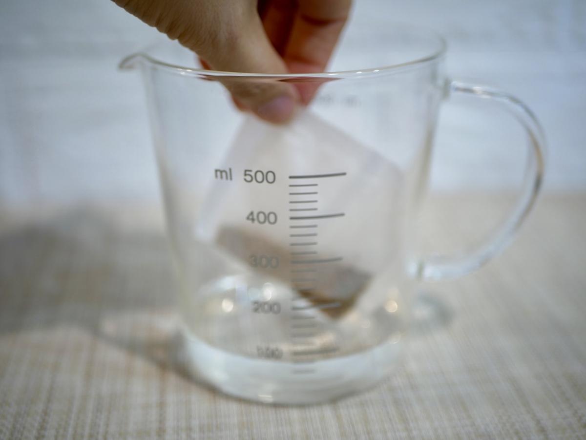 無印良品の耐熱ガラス メジャーカップにチャイの茶葉を入れている様子