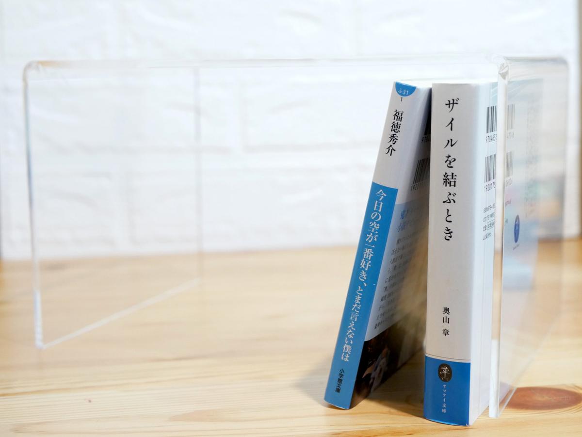 無印良品「アクリル仕切棚・大」に２冊の本が立ててある様子