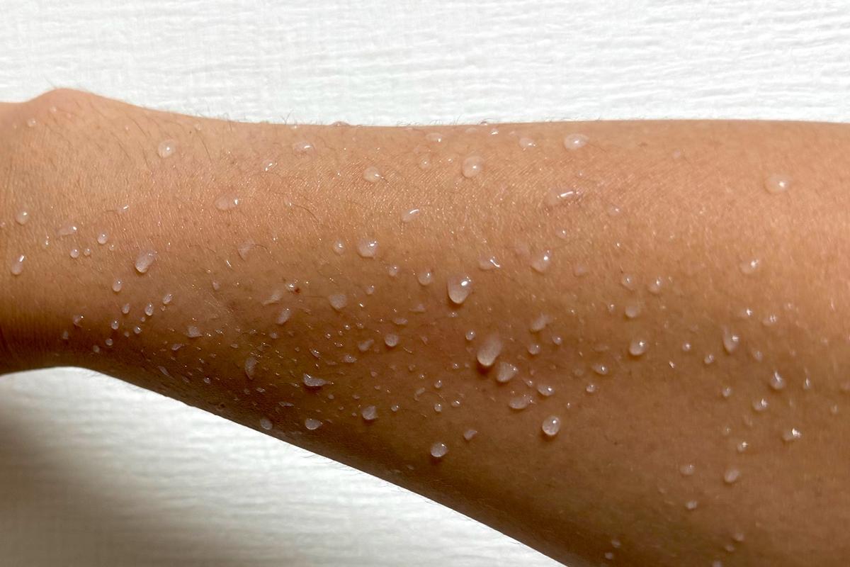 濡れた腕、水が浸透せず、弾くように水滴が付いている様子