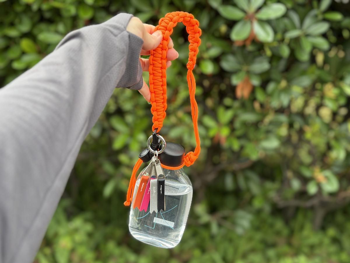 ドリンクチャームを装着した無印良品「水ボトル」を外で使う様子