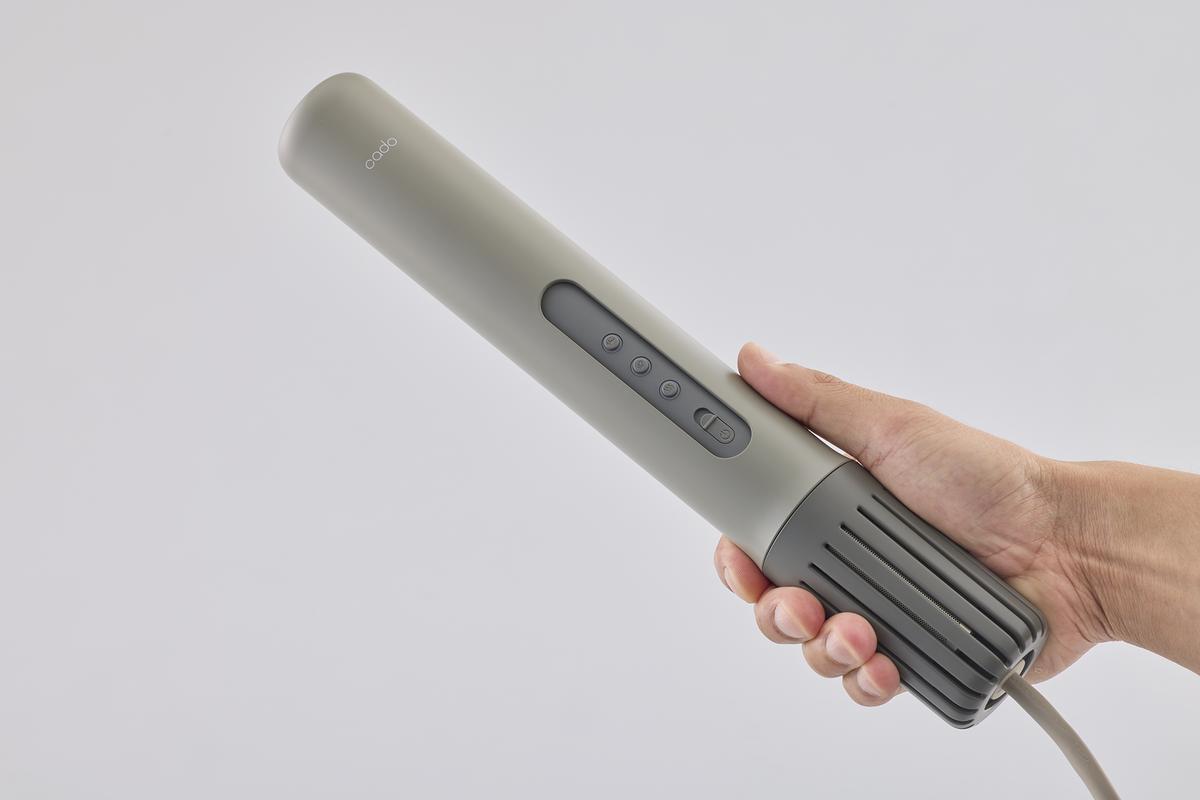 cadoの「SELF-CLEANING KIT FOR DOWN JACKETS with EFNAL」の布団乾燥機を持っているところ